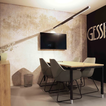 Konferenzraum mit Holztisch, sechs grauen Stühlen, Wandbild 'GESSI THE PRIVATE WELLNESS COMPANY' und Wandfernseher