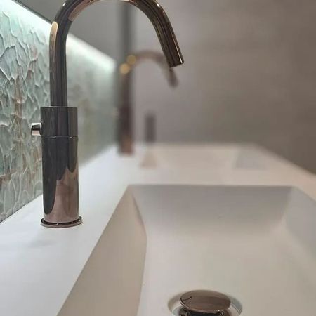 Moderner Wasserhahn über rechteckigem weißem Waschbecken in Badezimmer