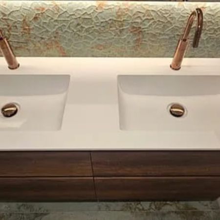 Modernes Badezimmer mit beleuchtetem Spiegel, dunklem Holzwaschtisch und Badewanne mit Wandarmatur