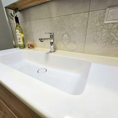 Moderner weißer rechteckiger Waschtisch mit verchromtem Einhebelmischer und dekorativen Wandfliesen im Badezimmer