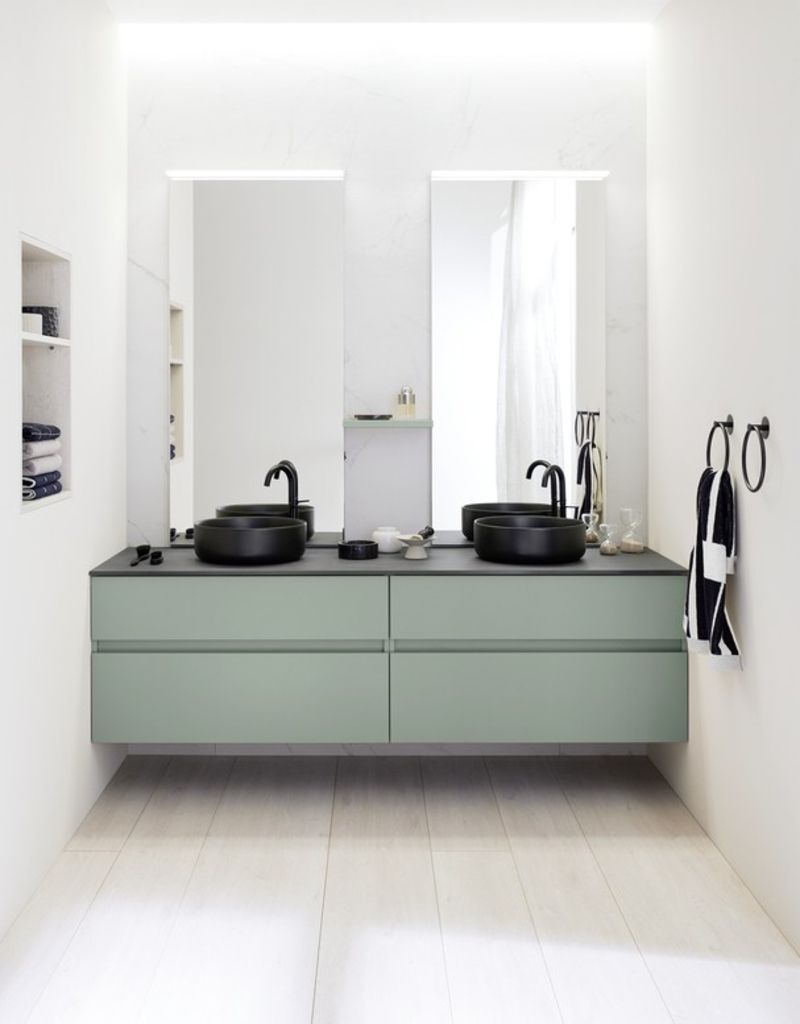 Modernes Badezimmer mit grünem Doppelwaschtisch, schwarzen Waschbecken und Armaturen, zwei rechteckigen Spiegeln und weißen Wänden